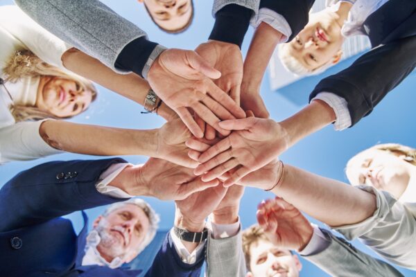 Community of people stacking hands together